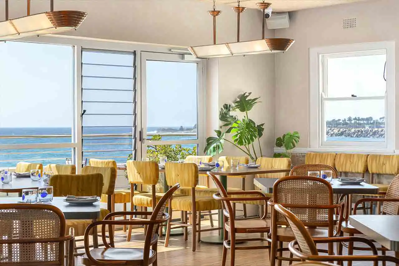 Upholstered banquette, dining chairs and tables at The Boathouse North Wollongong